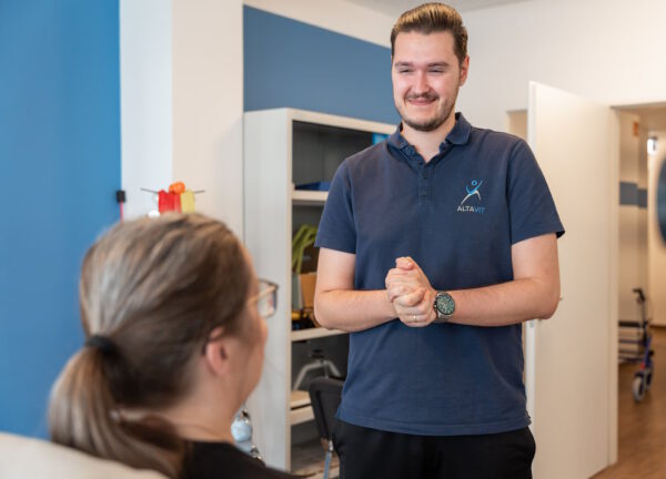 Physiotherapeut mit Patientin am Gerät